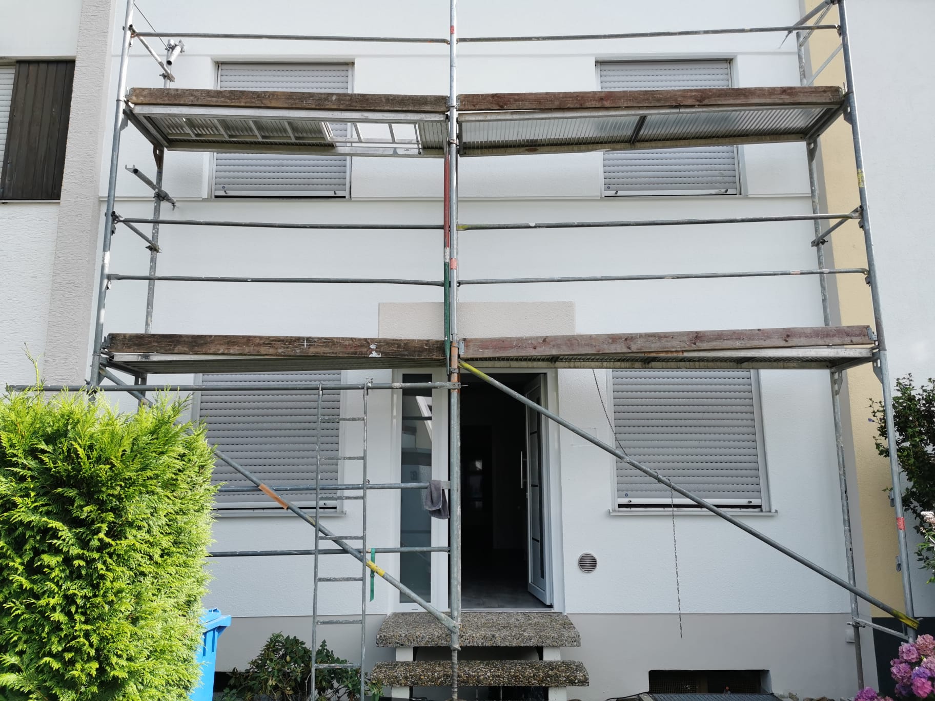 Fassadenarbeiten an einem eingerüsteten Wohnhaus