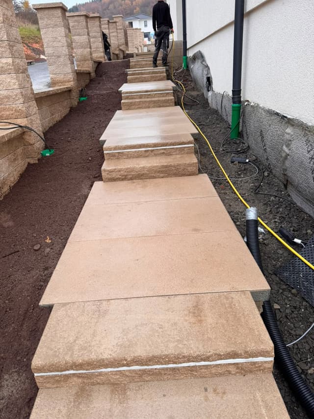 Gartenweg mit Blockstufen entlang einer Mauer